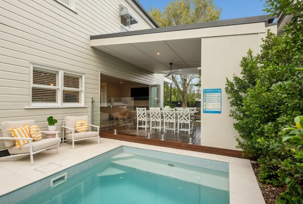 Swimming pool beside covered outdoor entertaining area